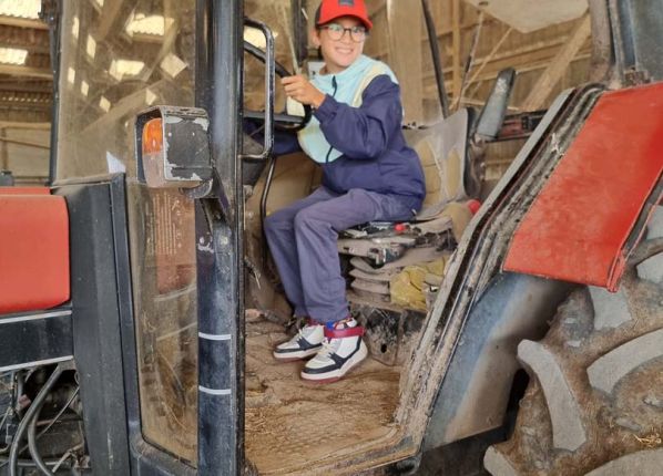 Un garçon au volant du tracteur