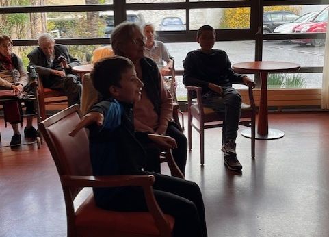 Un jeune garçon joue à un jeu vidéo avec une dame âgée