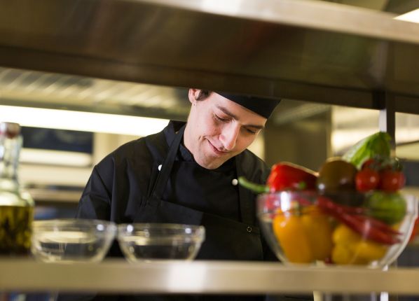 Cuisinier derrière des étagère dans une cuisine de restaurant