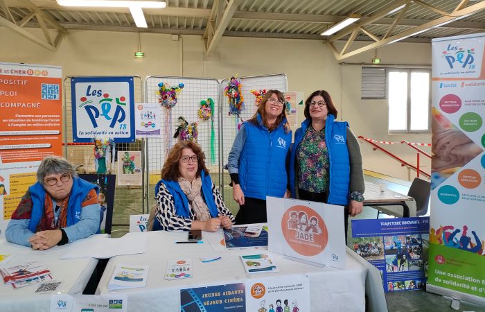 Groupe de Salariés et bénévoles de l'Asso PEP18 derrière une table / stand